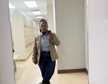 Zandile takes a selfie in a mirror at work.