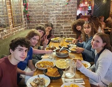 Students sit around a table at the welcome dinner