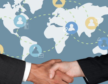 Illustration of hands shaking in front of world map