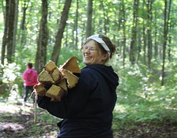 Venla S. of Finland carries firewood one afternoon at camp.