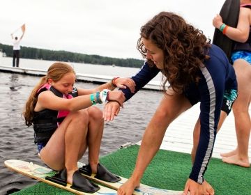 Summer camp counselor and student on water skis
