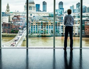 Businessman looking out window at London