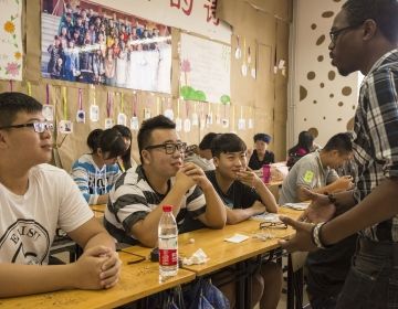 Teach in China teacher with his students in classroom