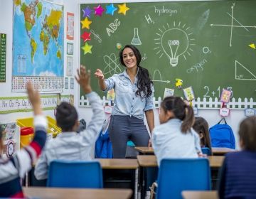 Teacher in front of class teaching her students