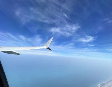 Shot of an airplane's wing out of a plane window
