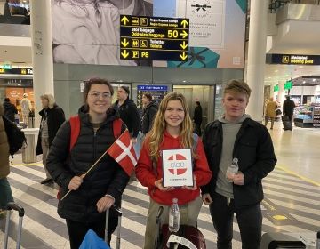 Students with the Denmark flag in the airport