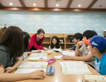 Teacher helping student in South Korean classroom