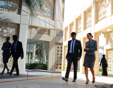 Business people in United Arab Emirates talking while walking down the street