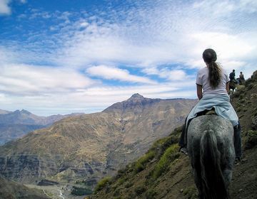 santiago ch girl riding a horse up a mountain side