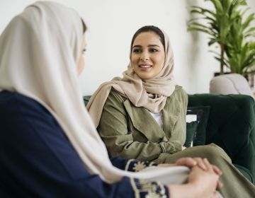 Saudi Arabian women conversing on couch
