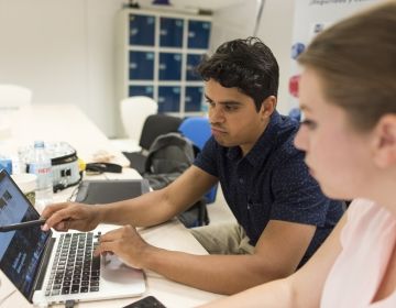 Two students sit together looking at a laptop during CIEE global internship program