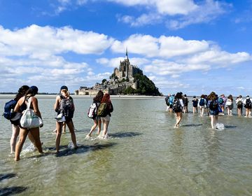 hssa rennes students walking in the low tide to mont st. michael