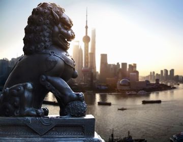 shanghai temple lion in front of the city skyline