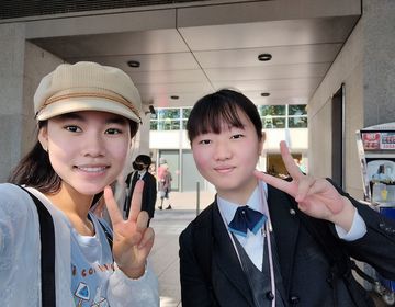 Two high school girls posing with peace signs in school hallway