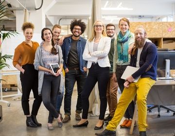 A group of people standing together in an office setting