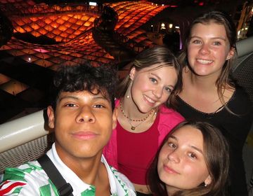 High schoolers smiling together in a group while studying abroad
