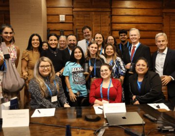 Group photo of CIEE senior leadership with San Antonio partners seated and standing around a conference table.