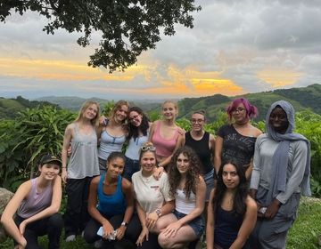 Monteverde high school students posing in front of a forest sunset