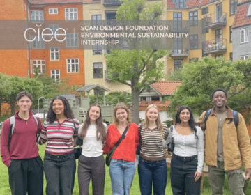 Logo top left: CIEE Scan Design Environmental Sustainability Internship above seven students (ages 19-22, 2 male, 5 female) who are shoulder-to-shoulder and smiling in an outdoor setting