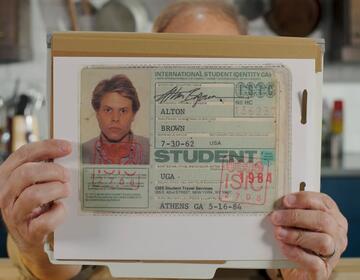  Alton Brown Cooks Food, holding his ISIC card