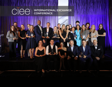 Award winners pose on stage accepting their awards