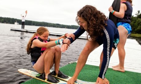 Summer camp counselor and student on water skis