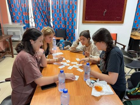 High school students sitting at table playing cards