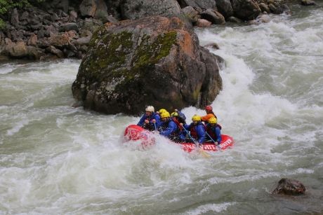 Whitewater rafting by a boulder