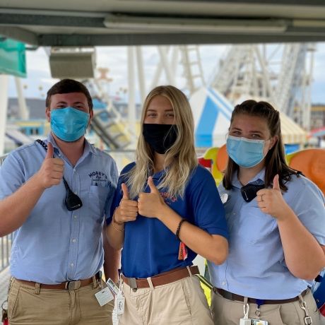 work and travel employees at amusement park wearing masks