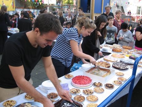 Students cutting cakes at a bake sale in Amsterdam