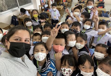 Teacher and students posing for camera in masks