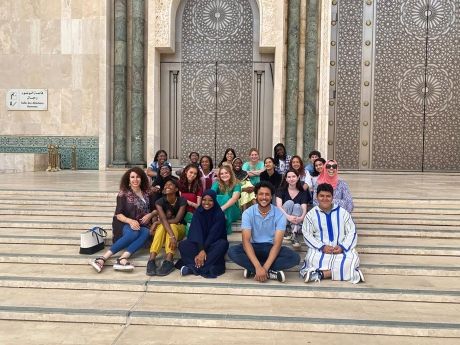 High school students sitting on steps of mosque in Morocco