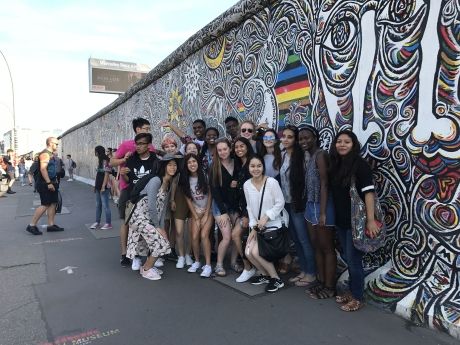 High school students posing in a group by street art in Berlin
