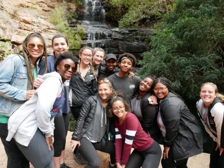 High school students posing by a waterfall on an excursion in Gaborone