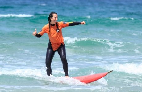 High school girl surfing at the beach in Lisbon