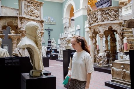 High school student looking at statue in museum in London