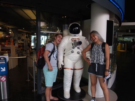 Two high schoolers posing with an astronaut suit in a Toulouse museum