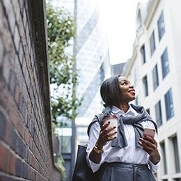 London smiling intern with coffee and cell phone