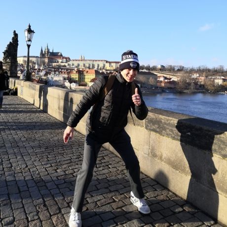 Prague student on Charles Bridge giving thumbs up