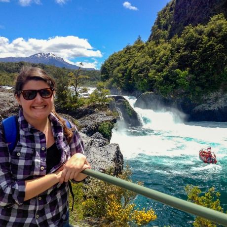 santiago ch student standing on platform overlooking a waterfall and a boat in the lake