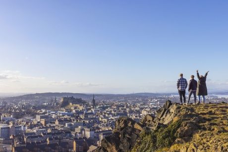 Three students on Salisbury Crags overlooking the city of Edinburgh