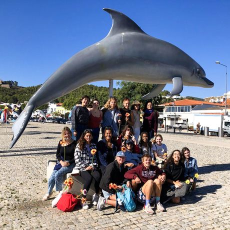 group of students at dolphin sculpture