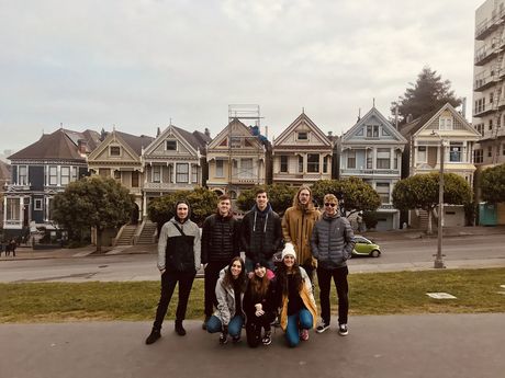 Students in front of houses in San Francisco on a cloudy day
