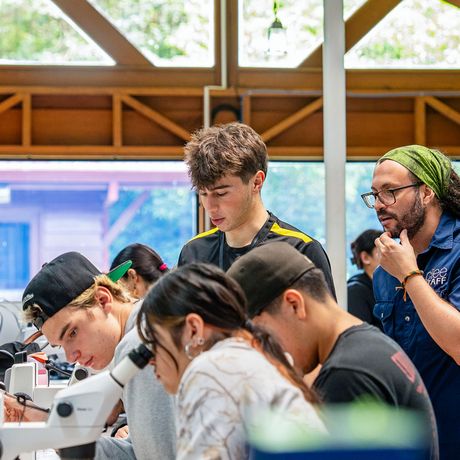 monteverde-staff-member-helping-students-microscopes