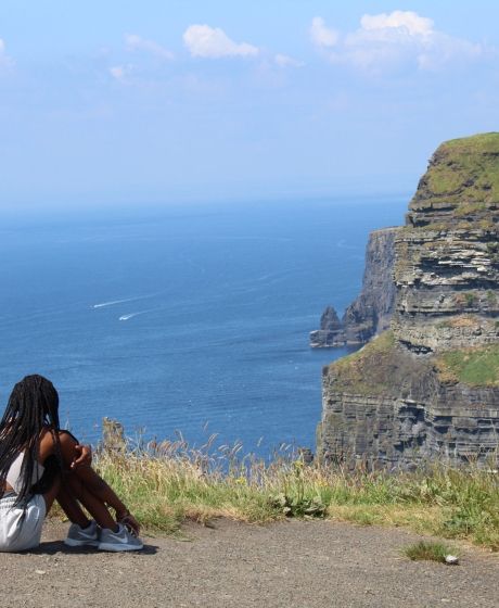 dublin girl overlooking castle on cliffs of moher