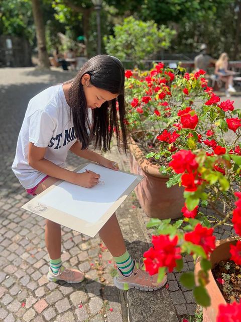 student drawing rose in garden