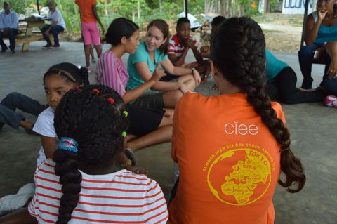 Student sitting with kids while volunteering abroad