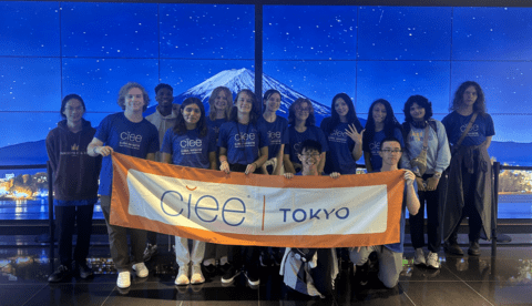 students posing with CIEE banner at tokyo arrival day
