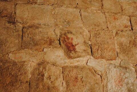 Red handprint on the wall of an arch in Uxmal