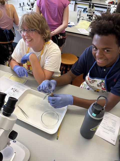Students smiling doing lab work together in classroom
